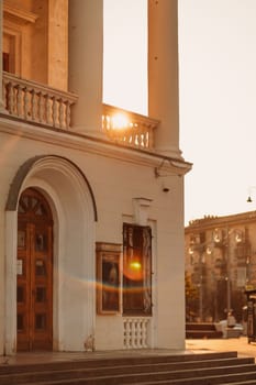 Facade of a white building at sunset. Solar flare