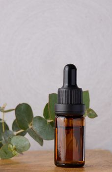 Brown glass bottle with pipette for cosmetic procedures on a wooden background