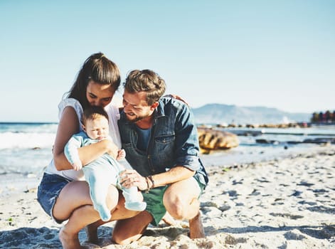 Babys first time at the beach. a young family spending quality time at the beach