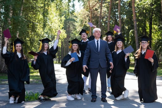 A university professor and seven robed graduates are jumping outdoors