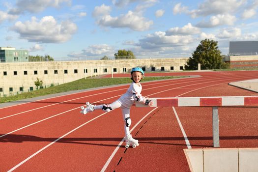 Girl in vintage white roller skates and a helmet at the stadium