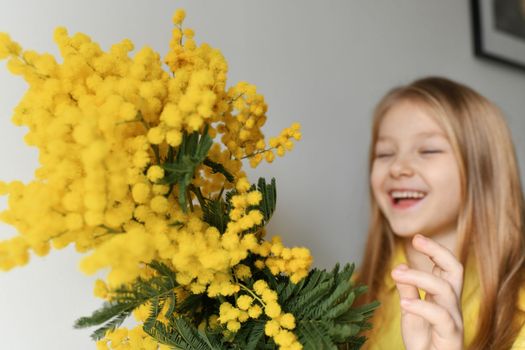 A girl smelling mimosa at spring