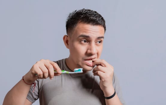 Young man with gingivitis holding toothbrush. People holding toothbrush with gum pain, Man holding toothbrush with gum pain, People holding toothbrush with gum problem isolated
