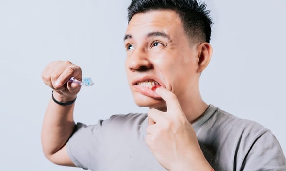 Man holding toothbrush with gum pain isolated, People holding toothbrush with gum problem isolated. Young man with gingivitis holding toothbrush, People holding toothbrush with gum pain