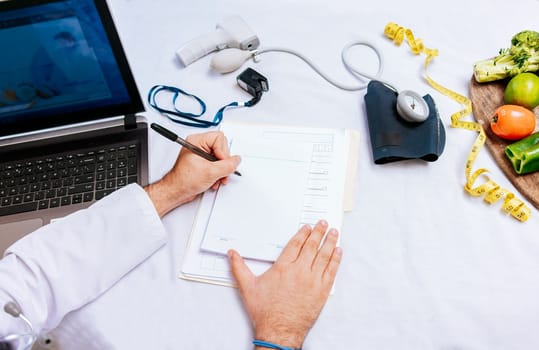 Top view of nutritionist writing on notepad. Concept of nutritionist taking notes on prescription, View of nutritionist taking medical records in the office