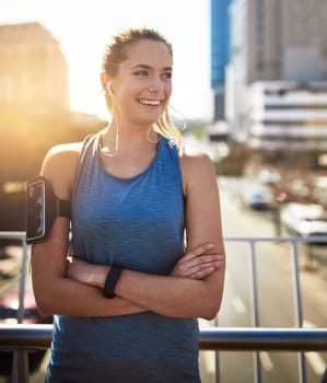 Getting fitter by the day. a sporty young woman standing with her arms folded outdoors