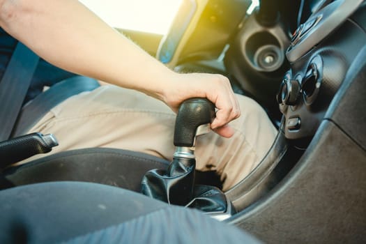 Close-up of driver hand on the gear lever of a car, Driver hand grabbing car gear stick, closeup of hands accelerating on gear stick