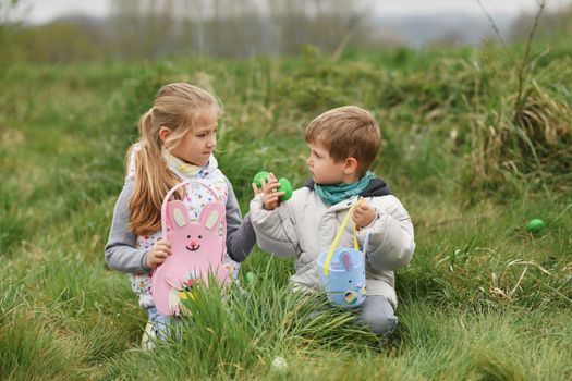 Children collects the eggs in a basket Easter