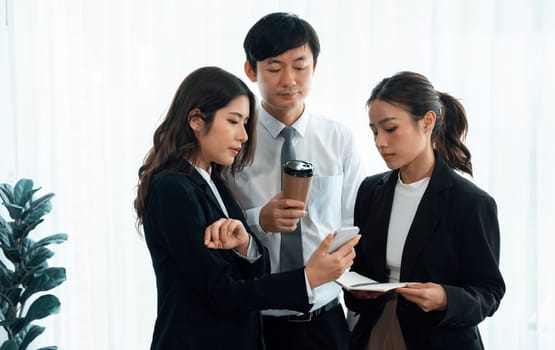 Mentor, manager with coffee advice younger colleagues in workplace. Businesspeople discussing or planning financial project strategy, talking together for harmony and strong teamwork in office concept