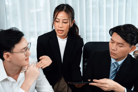 Harmony in office concept as business people analyzing dashboard paper together in workplace. Young colleagues give ideas at manager desk for discussion or strategy planning about project.