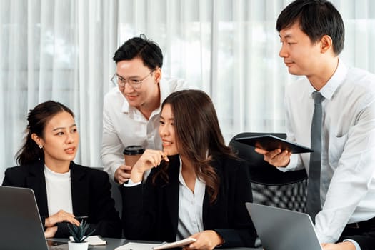 Harmony in office concept as business people analyzing dashboard paper together in workplace. Young colleagues give ideas at manager desk for discussion or strategy planning about project.