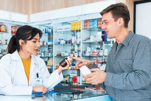 Professional pharmacist advise or explain property of qualified medical product to customer in pharmacy, druggist answer to client healthcare inquiry, medical service and consultation concept.