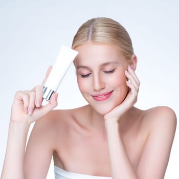 Closeup personable beautiful perfect natural skin woman hold mockup tube moisturizer cream for skincare treatment product advertising expressive facial and gesture expression in isolated background.