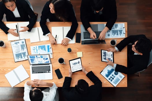 Top-view business team of financial data analysis meeting with business intelligence, report paper and dashboard on laptop for marketing strategy. Business people working together in office of harmony