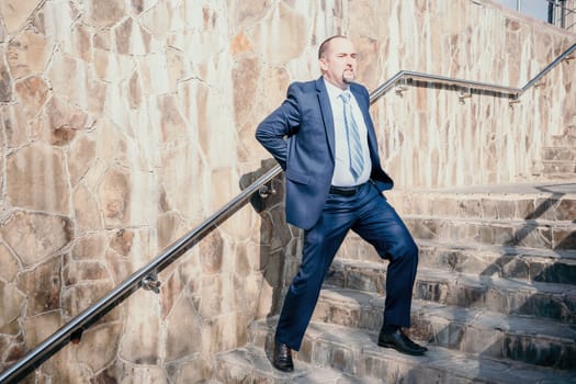Portrait of a senior professional man in a suit with various problems. A middle-aged businessman with a briefcase descends the stairs.