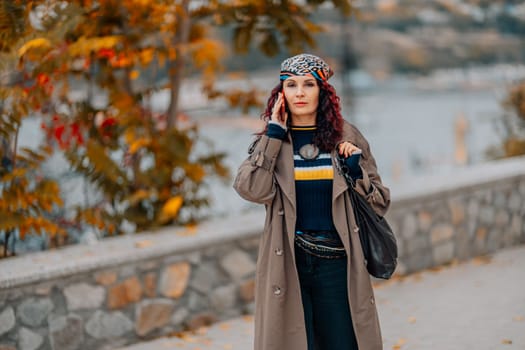 A woman walks outdoors in autumn, enjoys the autumn weather