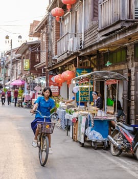 Chiang Khan village North Eastern Thailand February 2023, people on bycicle alongside the Mekong river. A traditional village with wooden house Chiang Khan