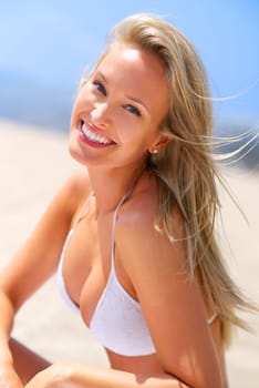 Sea, sun and summer fun. A gorgeous young blonde woman enjoying summer on the beach