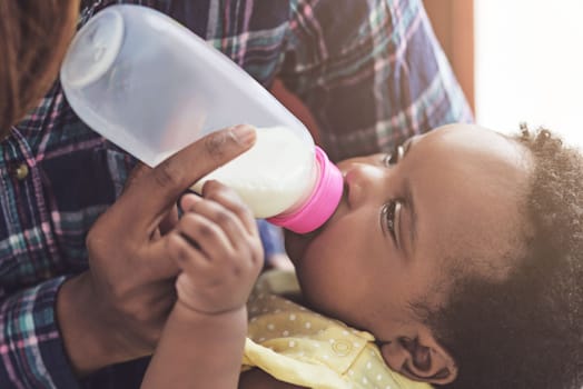 Dependent on her mothers love. a mother feeding her baby girl at home