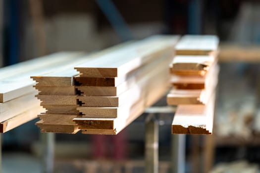 wooden boards on a rack in a carpentry shop. High quality photo