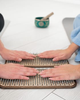 Close-up of two women's hands on sadhu boards. Nailing practice