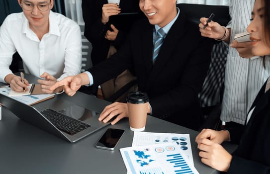 Harmony in office concept as business people analyzing dashboard paper together in workplace. Young colleagues give ideas at manager desk for discussion or strategy planning about project.