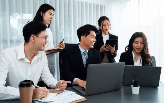 Harmony in office concept as business people analyzing dashboard paper together in workplace. Young colleagues give ideas at manager desk for discussion or strategy planning about project.