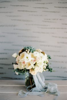 Bridal bouquet stands on the table against the background of the wall. High quality photo