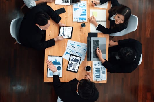 Top-view business team of financial data analysis meeting with business intelligence, report paper and dashboard on laptop for marketing strategy. Business people working together in office of harmony