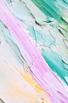 Smears of blue, pink, yellow and white paints on the wall, background or texture