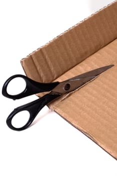 Cut cardboard with scissors isolated on a white background close up