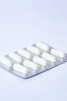 Packing of white tablets on a blue background, copy space