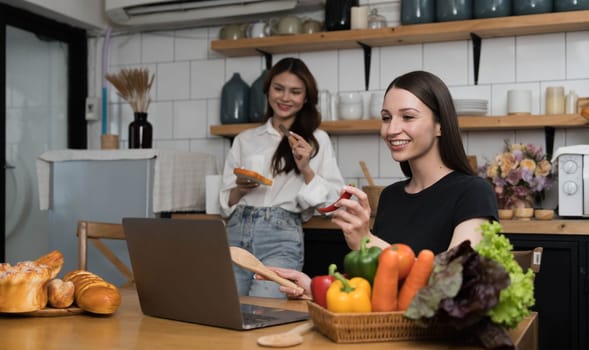 Female and female or LGBT couples are happily cooking bread together with happy smiling face in kitchen at home..