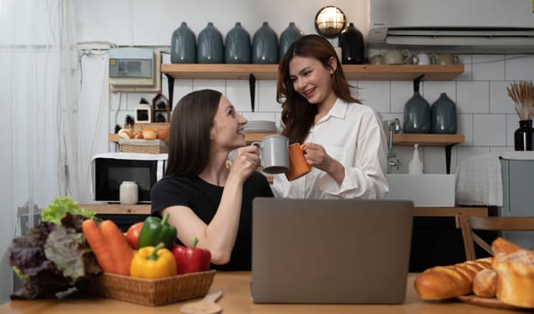 Female and female or LGBT couples are happily cooking bread together with happy smiling face in kitchen at home..