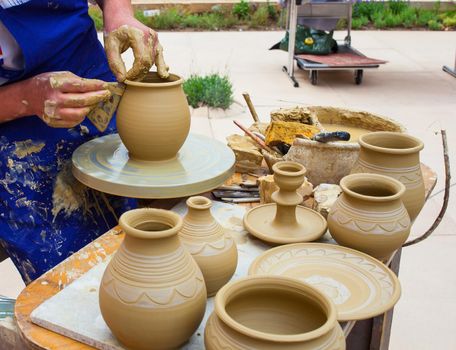 MILAN, ITALY - MAY, 20: Pottery maker uses a kick wheel to hand mold a pot from clay during the Expo, universal exposition on the theme Feeding the planet, Energy for life on May 20, 2015 in Milan