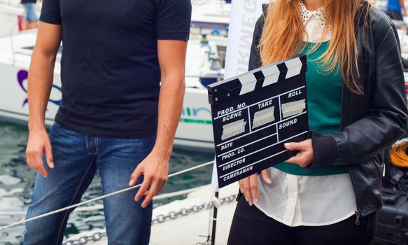 TRIESTE, ITALY - OCTOBER, 12: Girl holding clapperboard during the production of short film on October 12, 2014