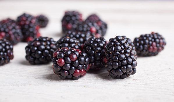 Close up of delicious blackberry on white wooden table