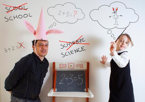 Little girl teaching mathematics to an adult dunce on little chalkboard