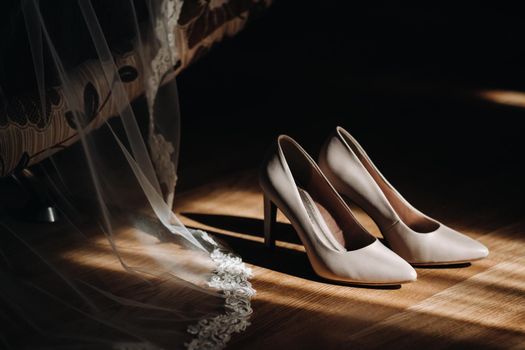 white wedding shoes standing on the field near the dress.