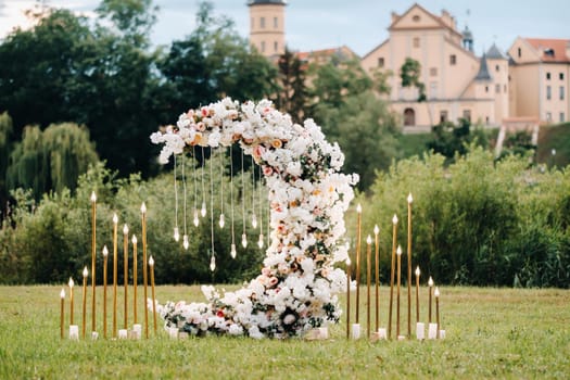 Wedding ceremony on b street near the Nesvizh castle.Decor with fresh flowers in the form of the moon