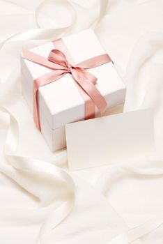 Romantic gift. Present on white silk background.