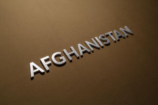the word afghanistan laid with silver metal letters on tan khaki canvas fabric