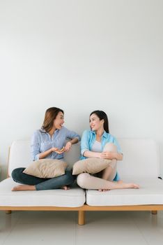 Two girlfriends having a talk on the couch  at home