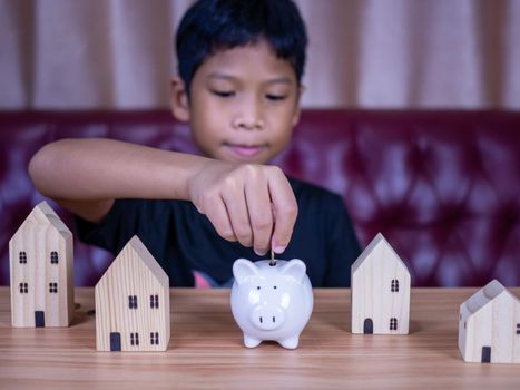 Boy saving money in a white pig piggy bank.Saving concept. Saving for the future.