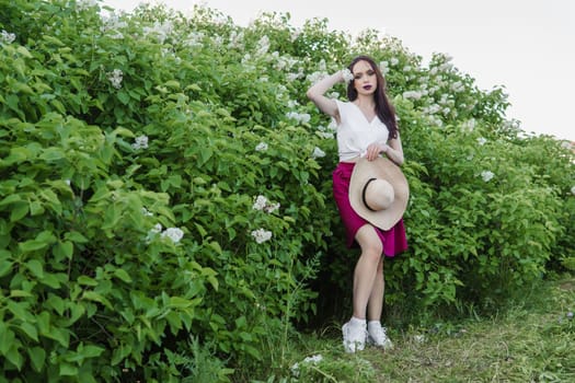 A fashionable girl with dark hair, a spring portrait in lilac tones in summer. Bright professional makeup