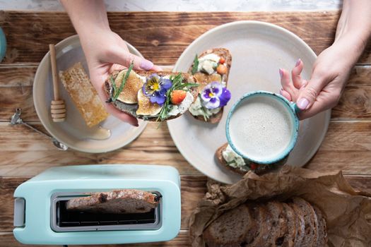 delicious bruschetta with homemade bread, garnished with fig,soft cheese,pansies, top view. High quality photo