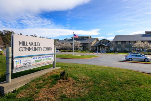 Mill Valley, California - February 22, 2023: Sign for Mill Valley Community Center and Hiring Notice with American Flag in Background. High quality photo