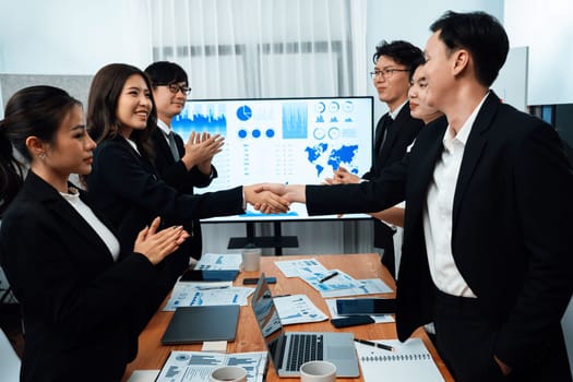 Businesspeople shake hand after successful agreement or meeting. Office worker colleague handshake with business team leader manager for strong teamwork in office to promote harmony and unity concept.