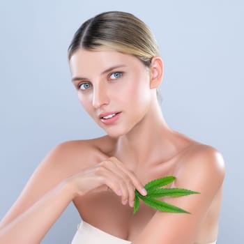 Alluring beautiful woman model portrait holding green leaf as concept for cannabis skincare cosmetic product for skin freshness treatment in isolated background.