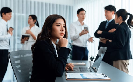 Focus portrait of female manger, businesswoman in the harmony meeting room with blurred of colleagues working together, analyzing financial paper report and dashboard data in background.